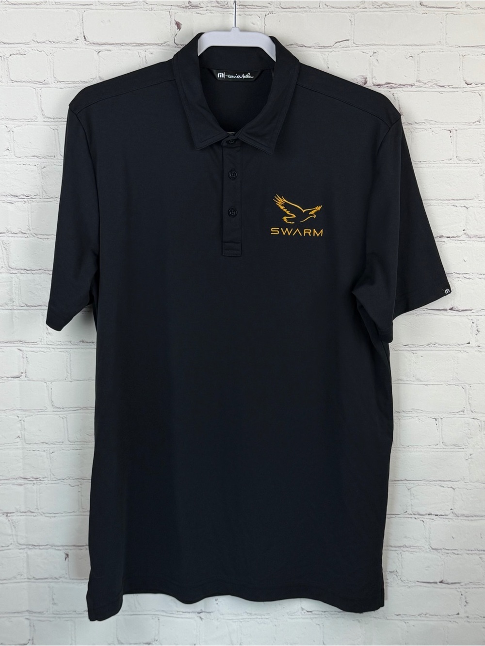 Travis Mathew Black Golf Polo with Gold SWARM Logo Large